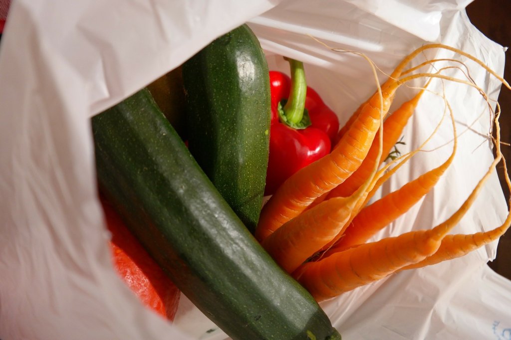Vegetables in a single-use plastic shopping bag.